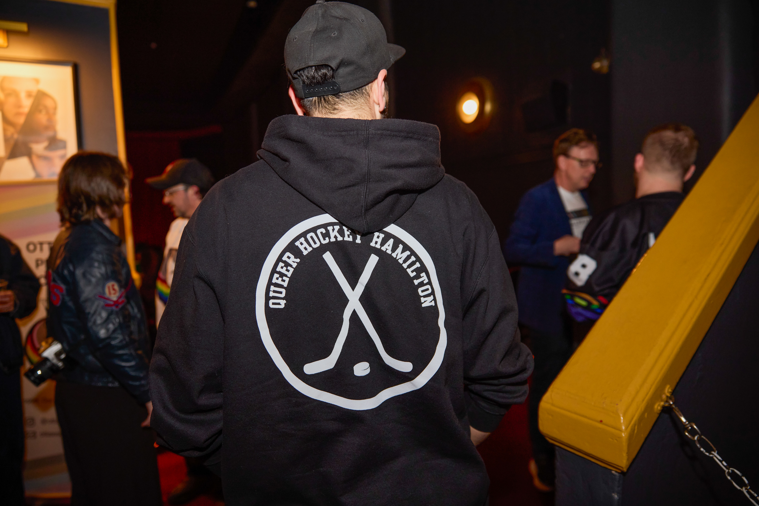 Person at Pink Light event wearing a "Queer Hockey Hamilton" hoodie.