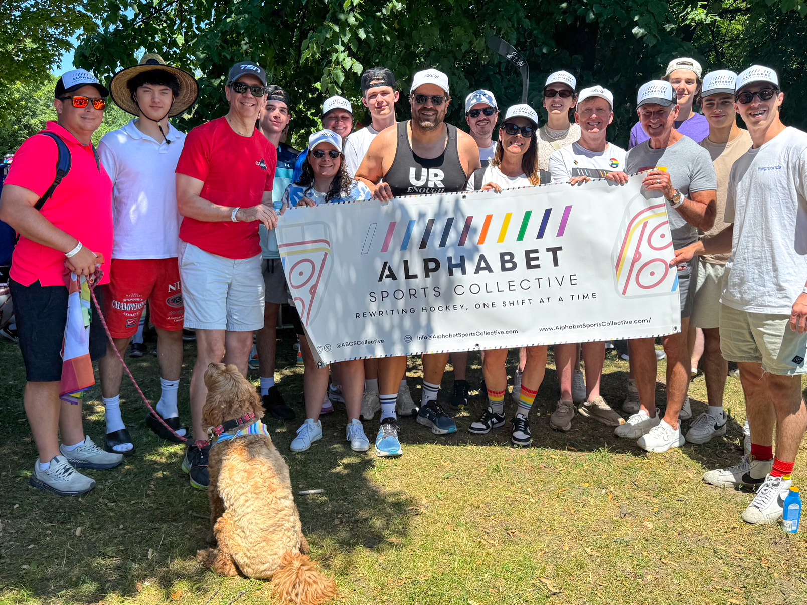 Alphabet Sports Collective members holding their banner in a group photo.